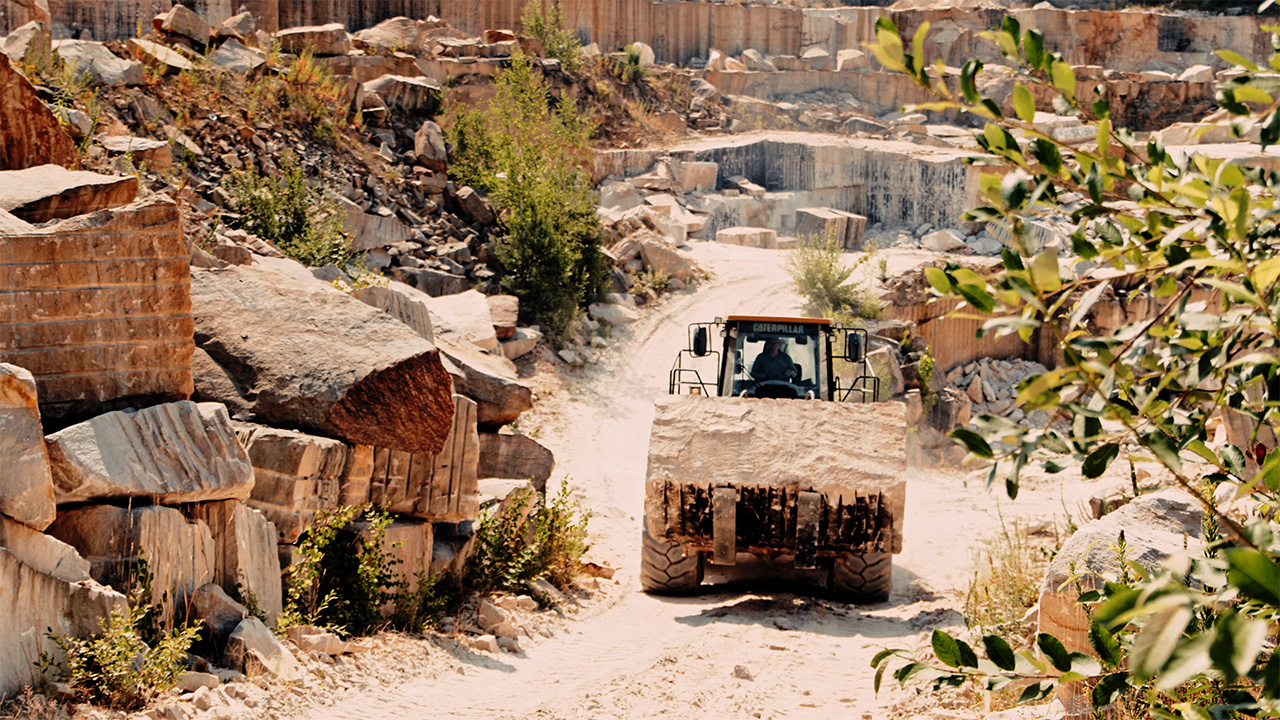 Una excavadora transporta piedra arenisca a la cantera